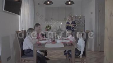 新年快乐四个孩子一家人庆祝新年厨房餐桌父亲儿子女儿笑妈妈端饭
